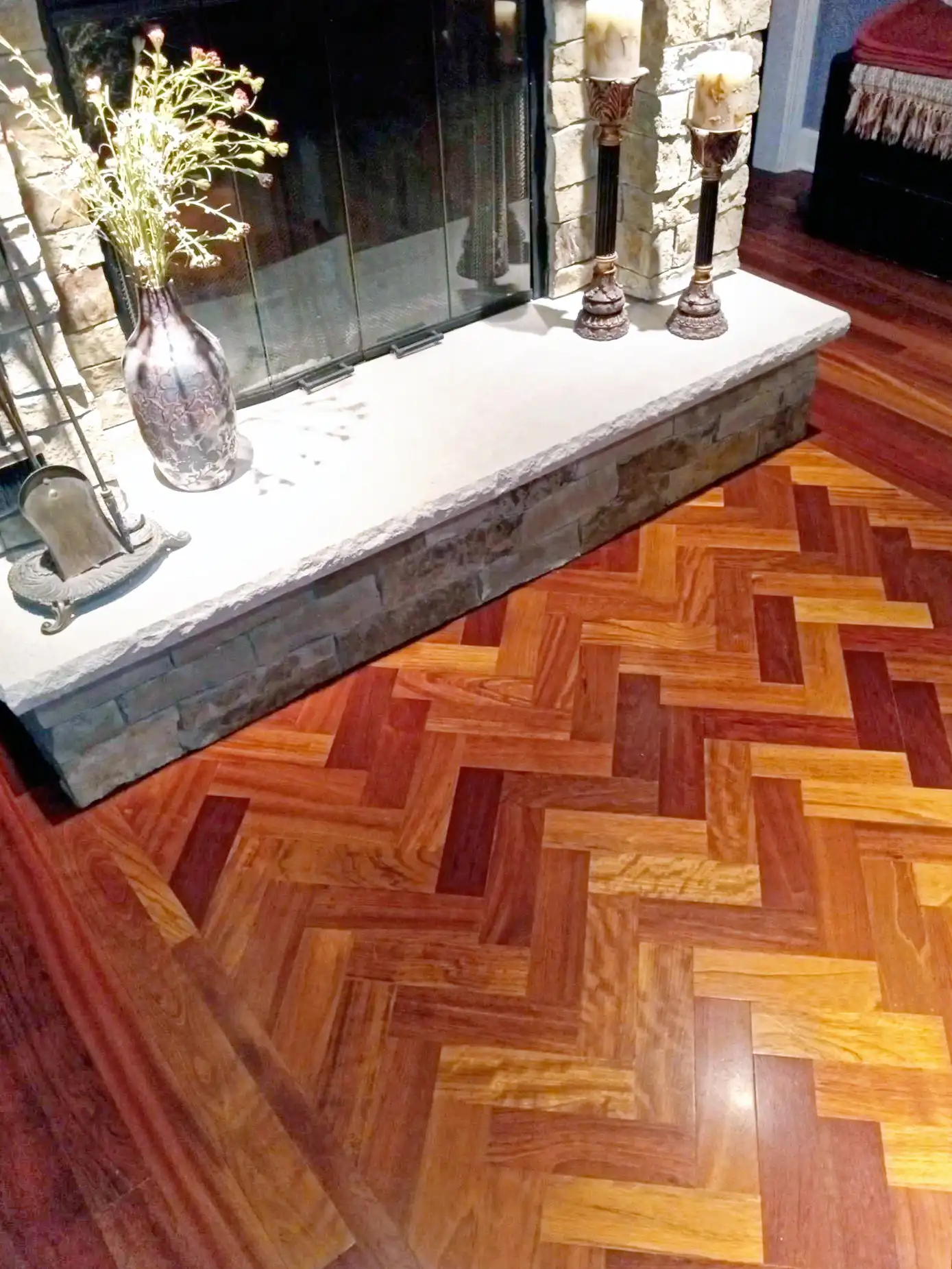 Herringbone hardwood flooring installation with fireplace undercutting