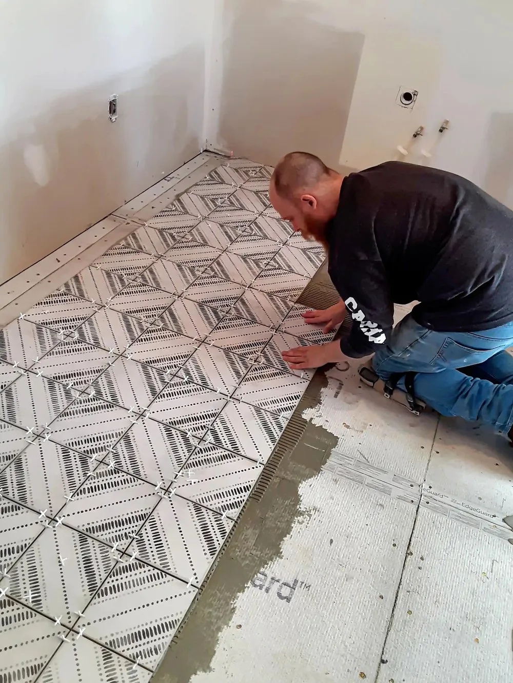 Subfloor preparation and back-buttered tile floor installation in progress on a Johnson County, Kansas project in Shawnee